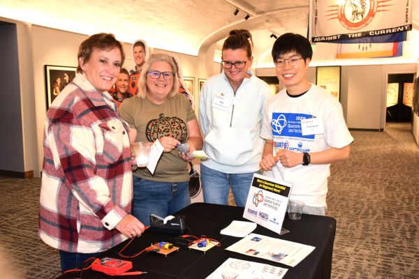 three teachers try an activity led by a scientist at right