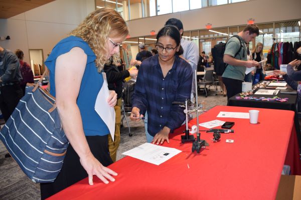 During a professional development conference, a teacher (left) learns a quantum science activity from a graduate student (right) with Nebraska's EQUATE research collaboration.