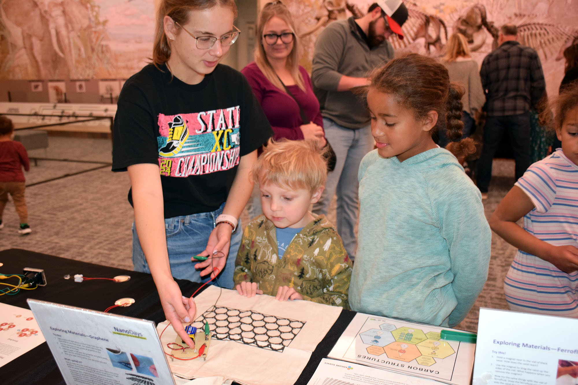 A student researcher explains graphene to elementary school-age students