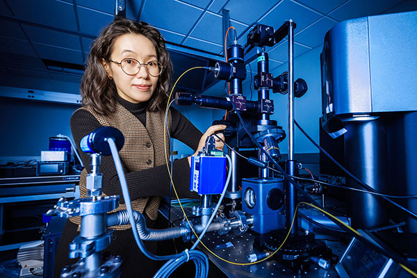In a laboratory, Yanan "Laura" Wang manipulates scientific equipment.