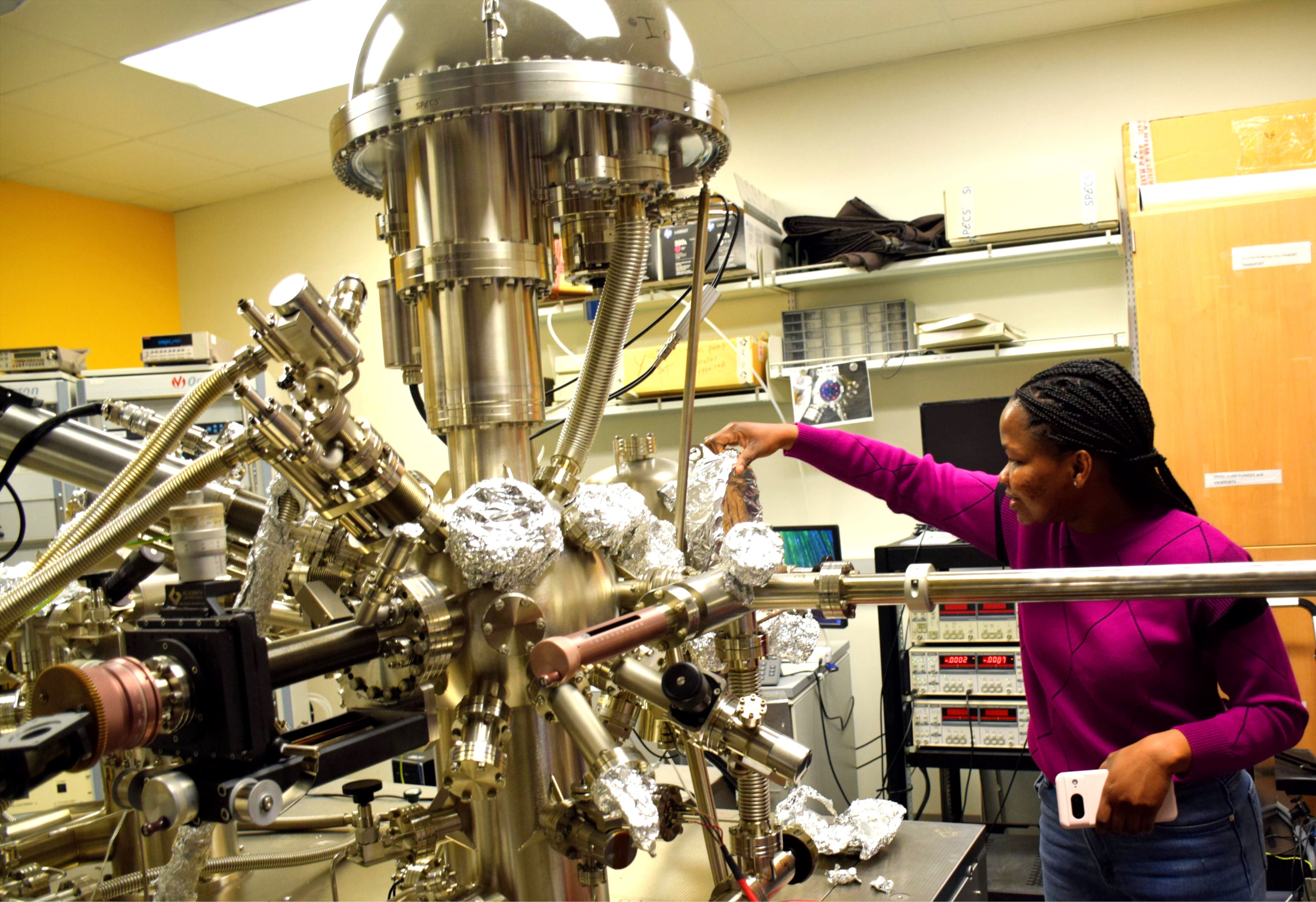 Peace Adegbite works with physics research equipment
